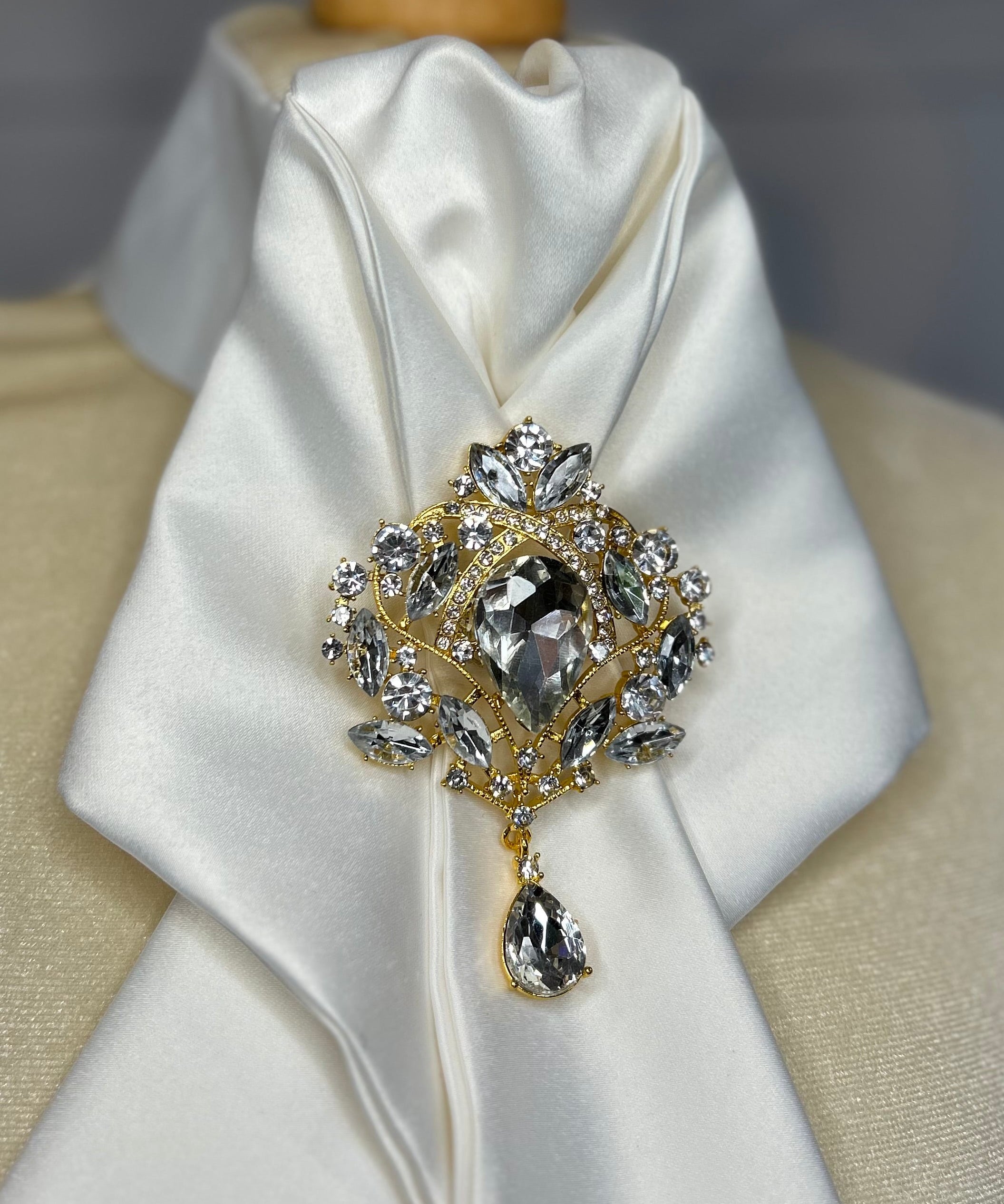 a crystal brooch pinned to an equestrian stock tie 