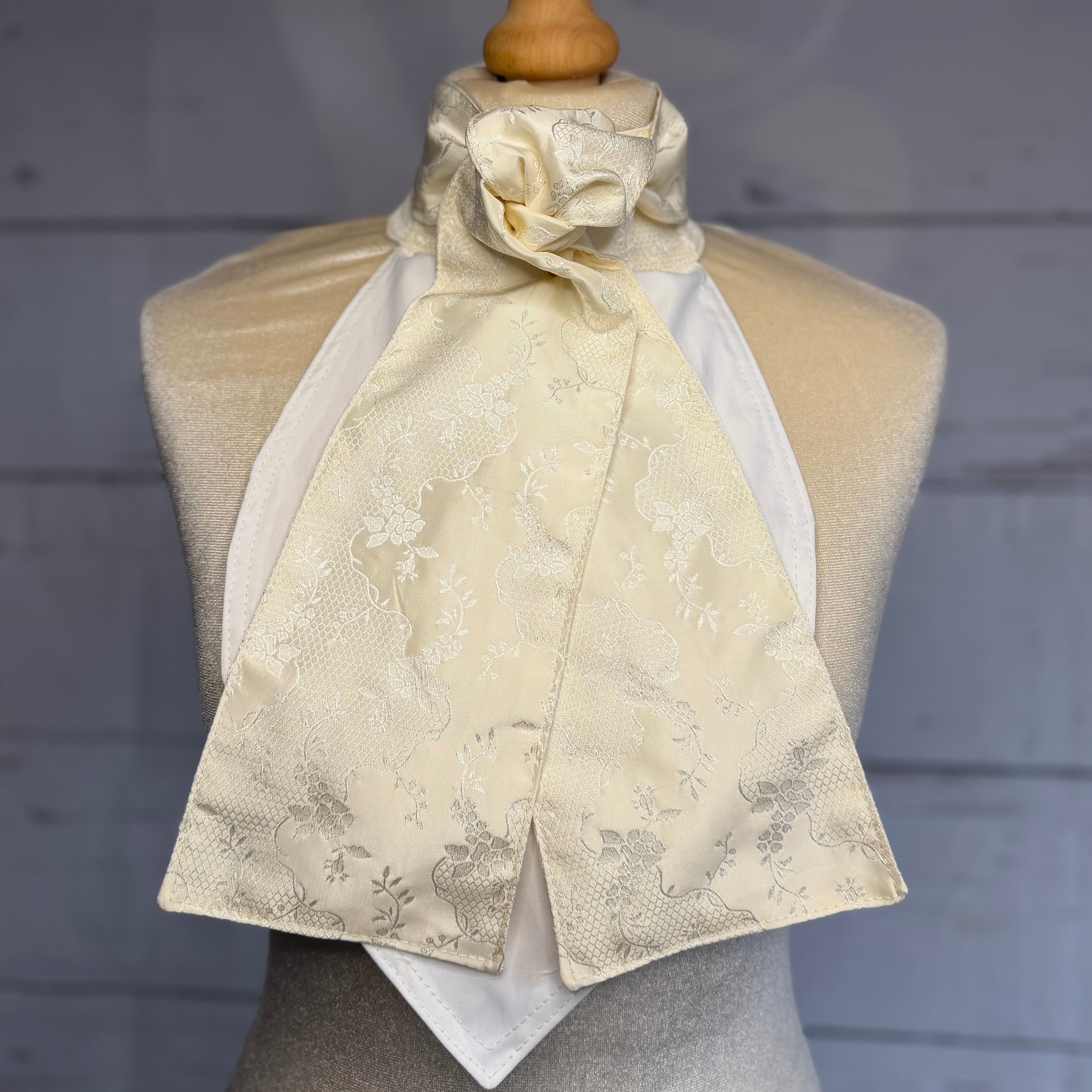an equestrian cream patterned self tie stock tie on a mannequin 
