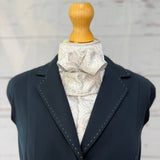 silver equestrian stock tie, on a mannequin wearing a blue jacket 