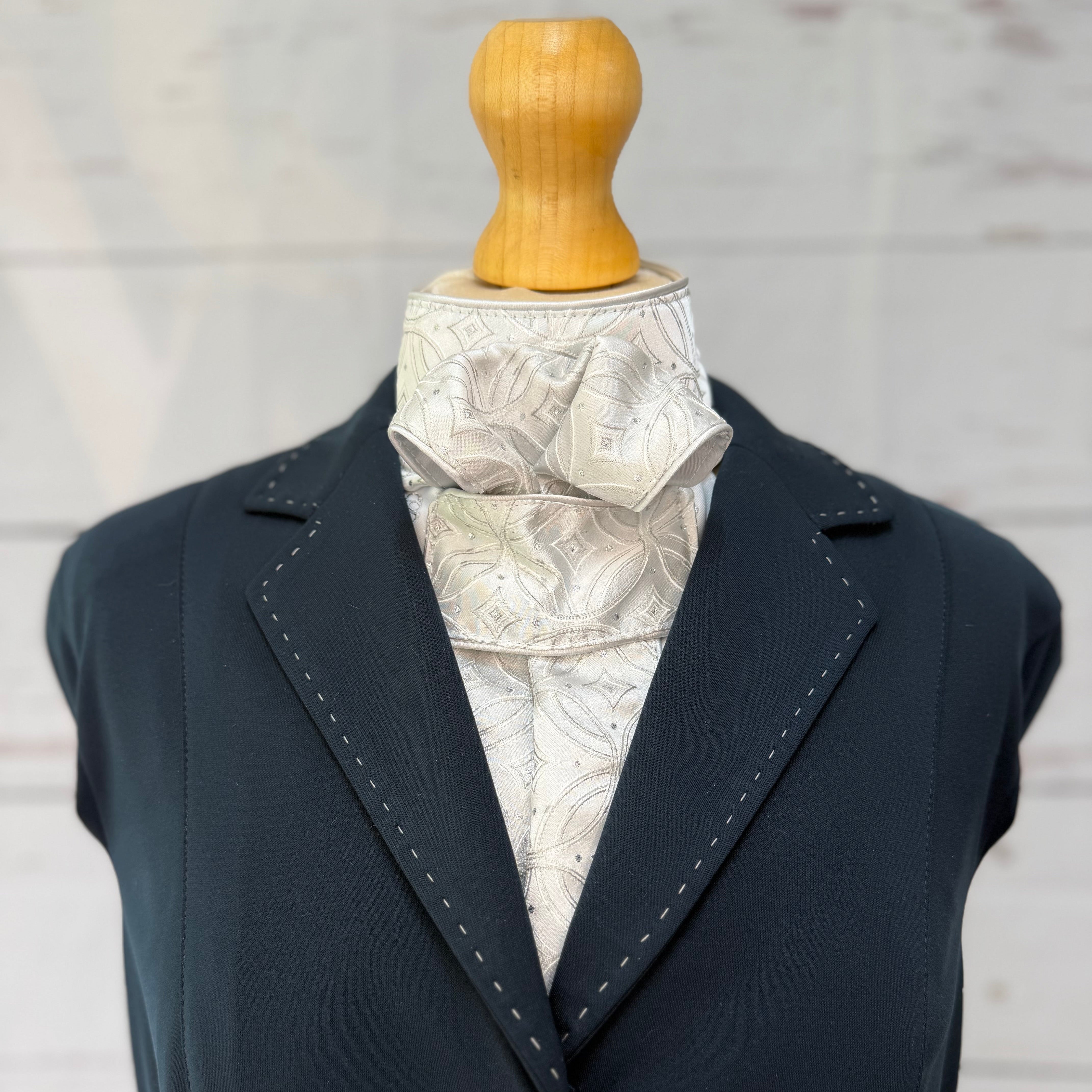 silver equestrian stock tie, on a mannequin wearing a blue jacket 