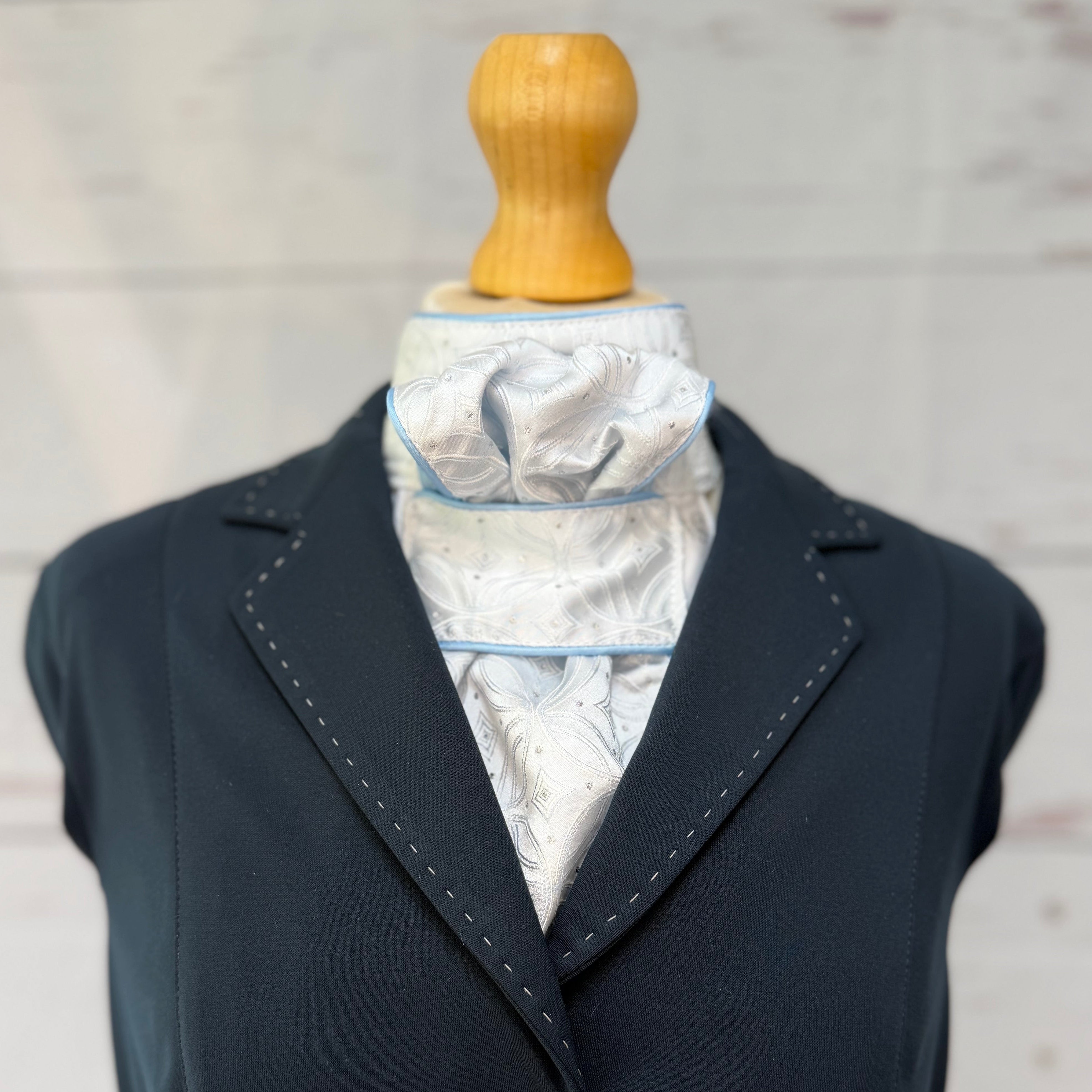 baby blue equestrian stock tie, with a blue jacket over the top. 