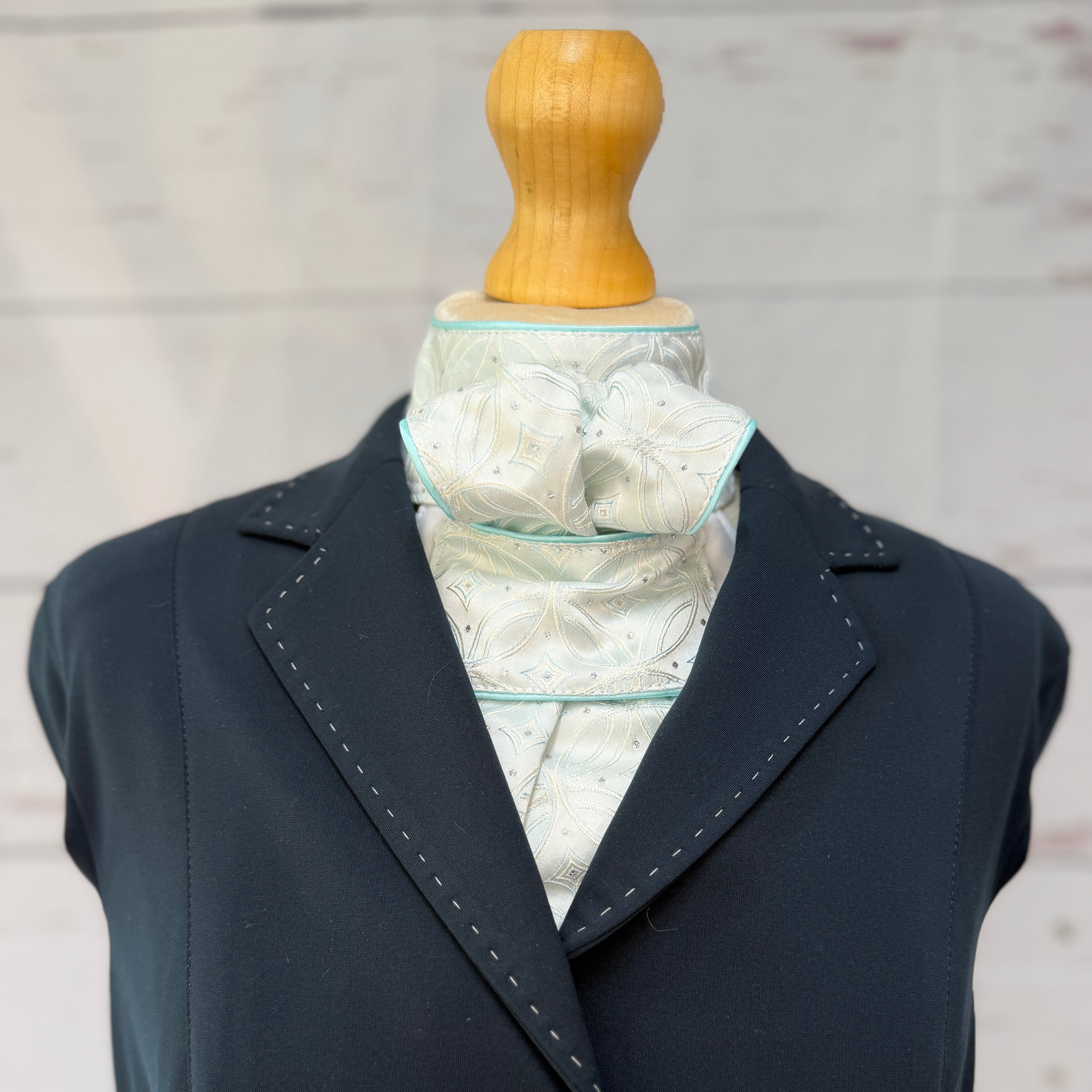 navy blazer on a mannequin wearing a aqua equestrian stock tie 