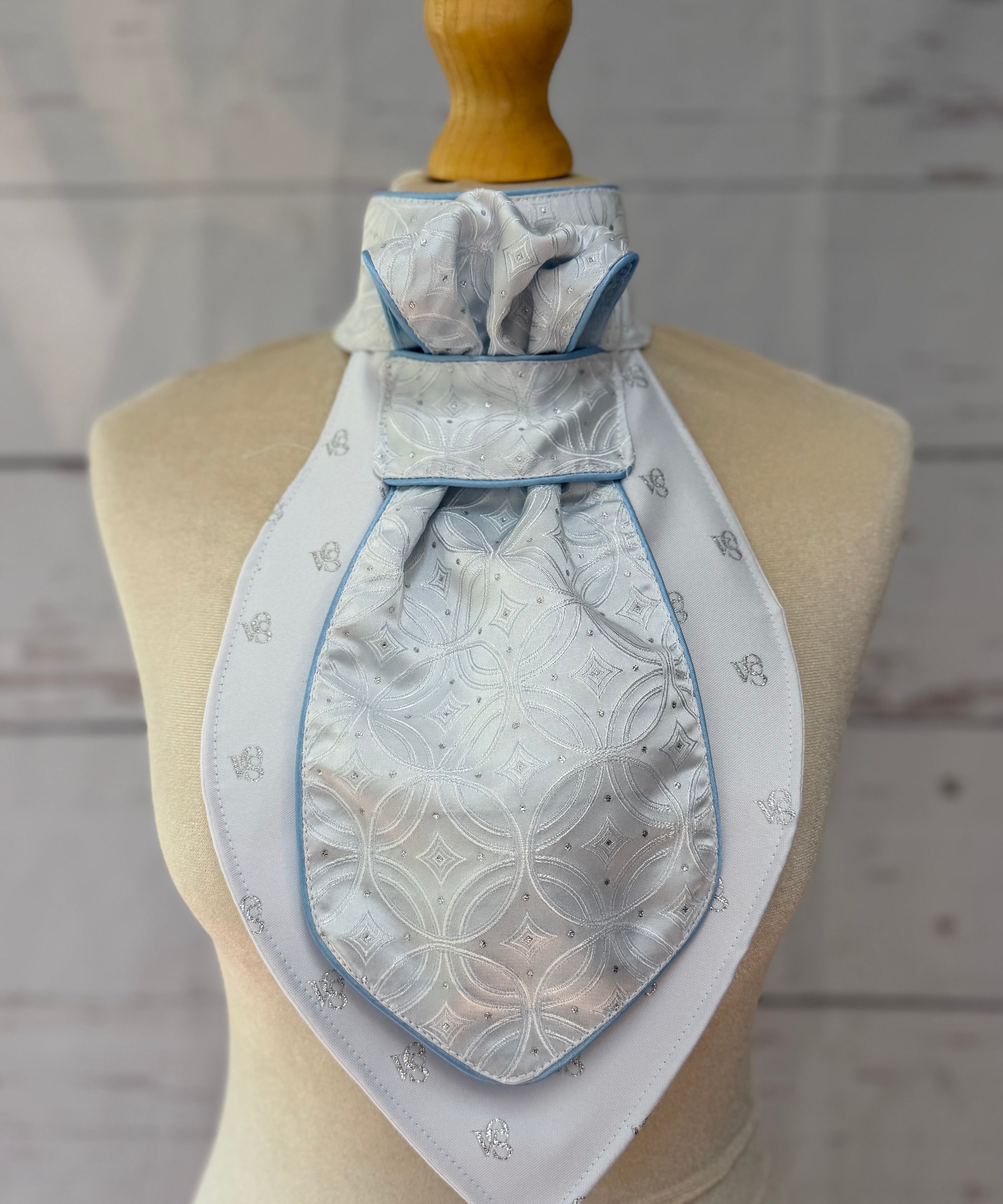 a baby blue equestrian stick tie with blue piping on a mannequin. 