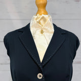 a blue jacket with a cream stock tie on a mannequin