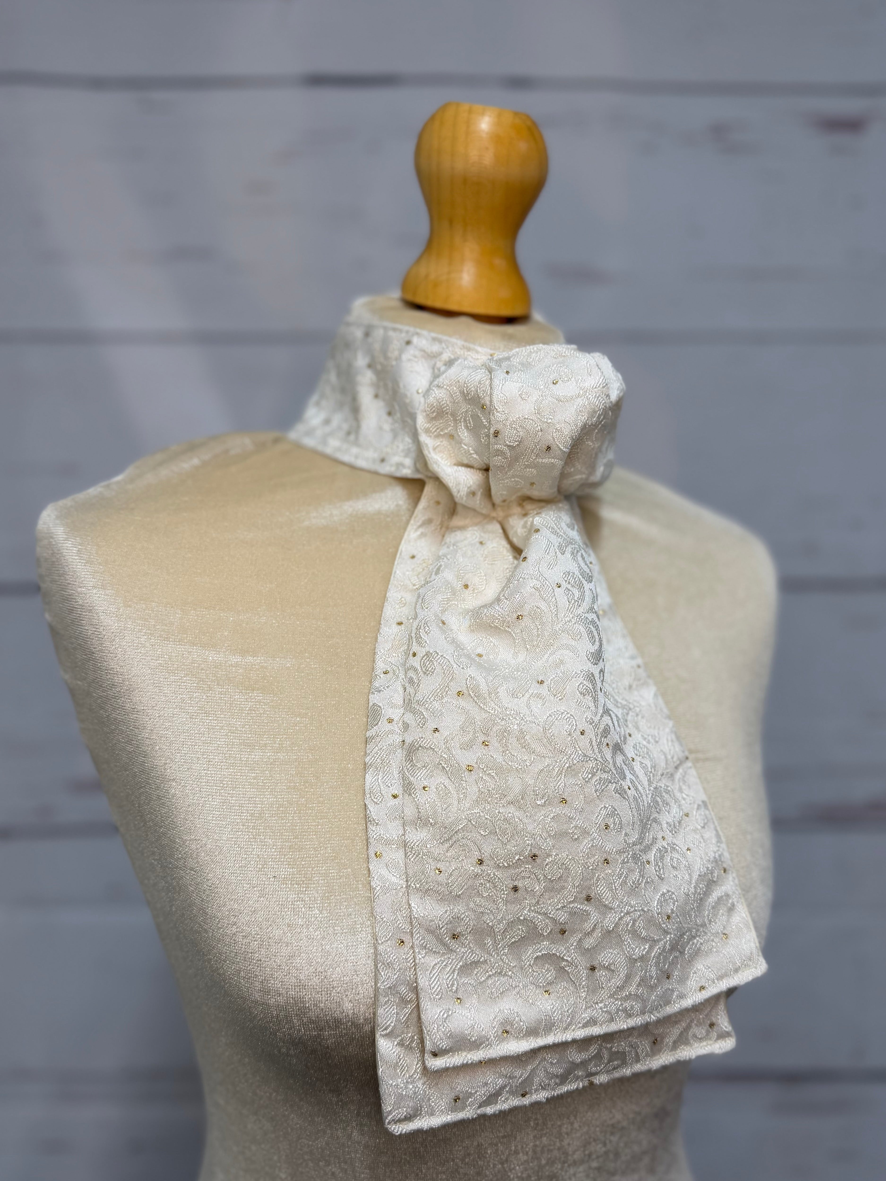 mannequin wearing a white and gold stock tie 