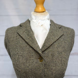 tweed jacket on a mannequin with a white satin stock tie