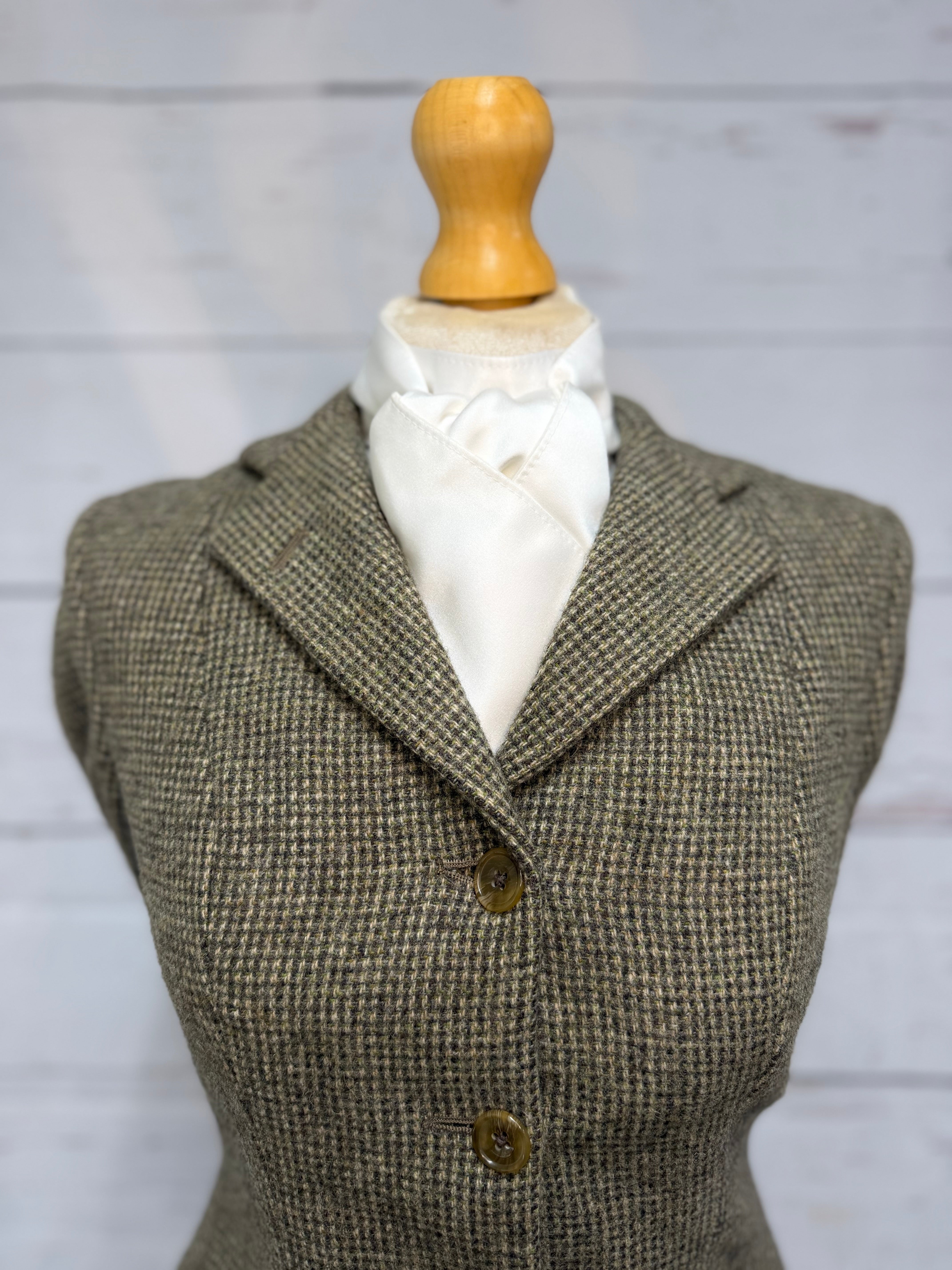 tweed jacket on a mannequin with a white satin stock tie