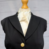black jacket on a mannequin with a cream satin stock tie