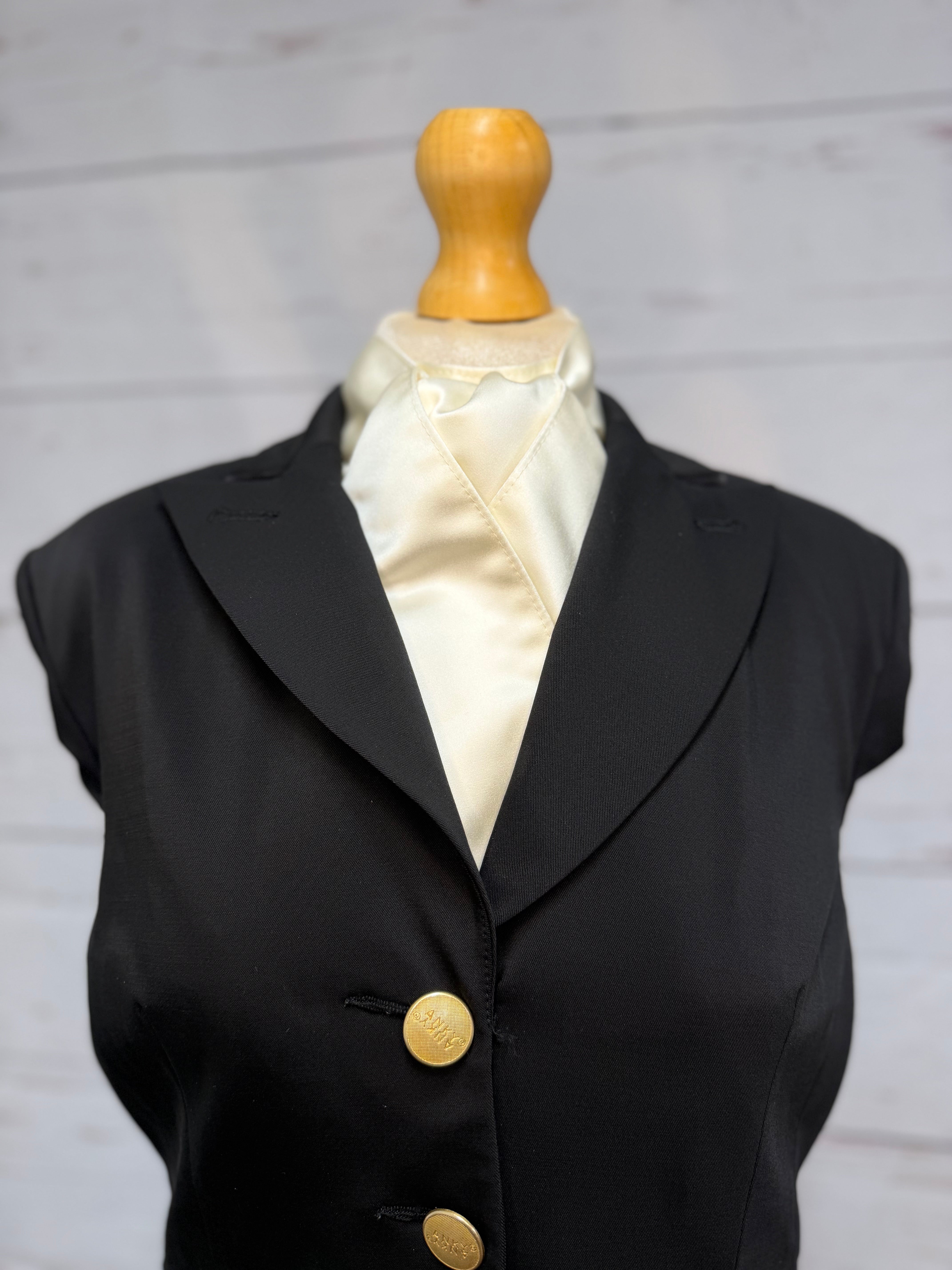 black jacket on a mannequin with a cream satin stock tie