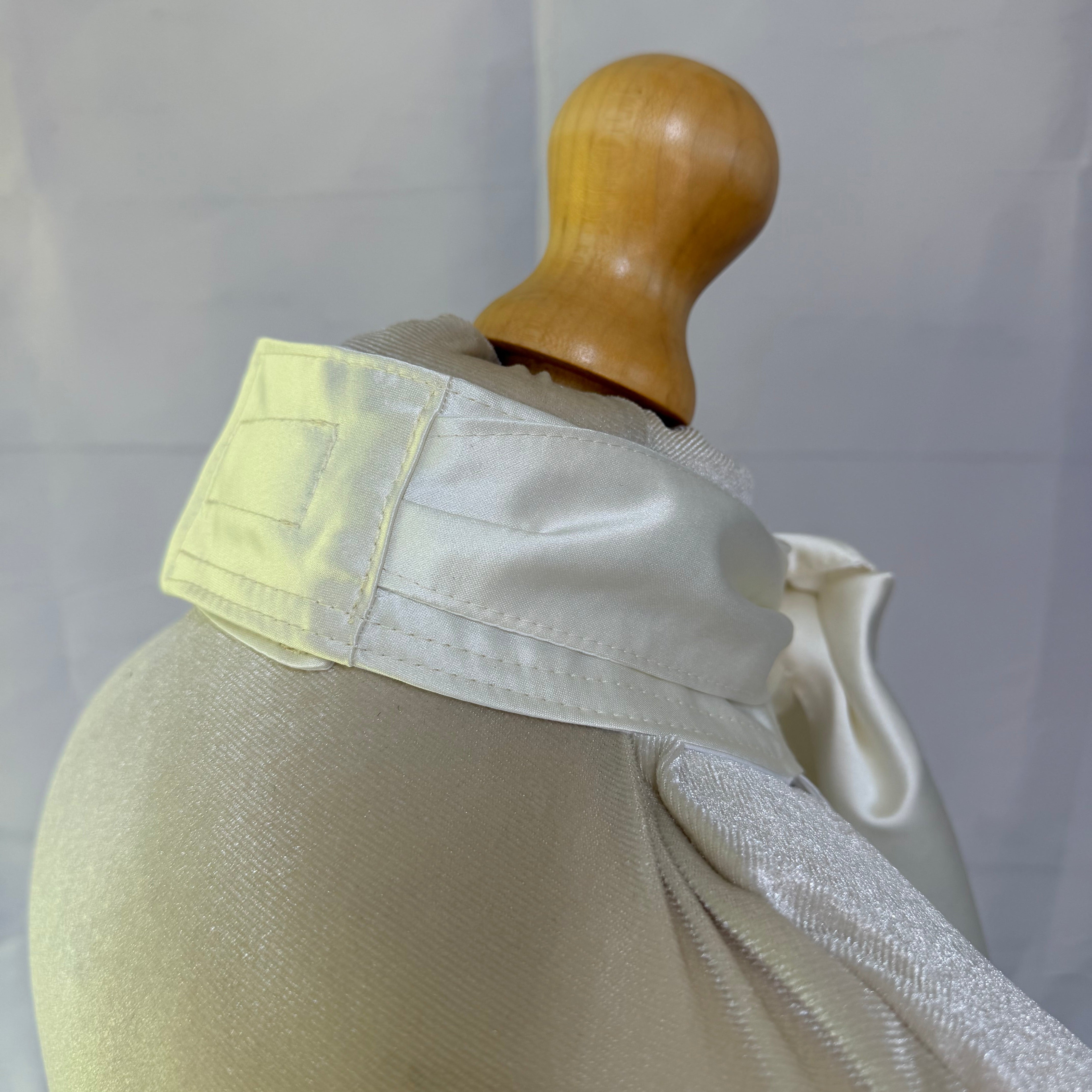 mannequin with satin cream sock tie plain background
