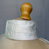 Mannequin head with a textured white cap on a gray background